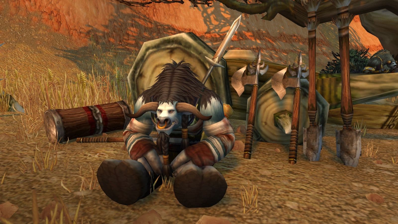 Un tauren assis dans une plaine, entouré de ses armes